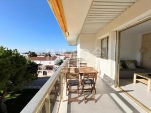 a balcony with a wooden table and chairs on it at Apartamento frente al mar en La Llosa Edif Olimpic 103A - INMO22 in Cambrils