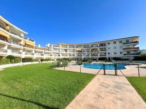 a large apartment building with a pool and a yard at Apartamento frente al mar en La Llosa Edif Olimpic 103A - INMO22 in Cambrils