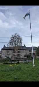 斯旺西的住宿－1 Bed cottage The Stable at Llanrhidian Gower with sofa bed for additional guests，建筑物前杆上的旗帜