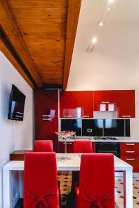 シラクーサにあるAppartamento Calarossaの赤い椅子と白いテーブル付きのキッチン