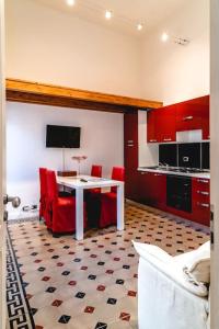 シラクーサにあるAppartamento Calarossaのキッチン(白いテーブル、赤い椅子付)