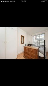 a bedroom with a bed and a dresser and a window at Covent Garden 2 Bed Apartment in London