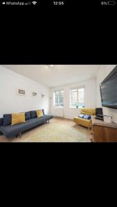 Covent Garden 2 Bed Apartment في لندن: غرفة معيشة مع أريكة زرقاء وتلفزيون بشاشة مسطحة