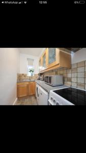cocina con armarios de madera y horno de fogón blanco en Covent Garden 2 Bed Apartment en Londres