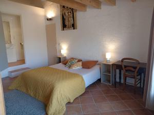 1 dormitorio con 1 cama y 1 mesa con silla en Maison de village, en Mollans-sur-Ouvèze