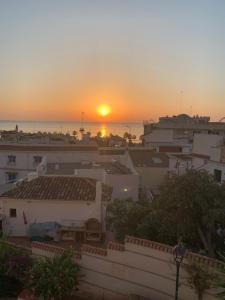 a sunset over a city with buildings and the ocean at Midway Apartamento in Torremolinos +17 photos