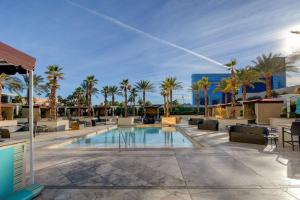 uma piscina com espreguiçadeiras e palmeiras em MGM Signature-29-804 Jacuzzi Studio em Las Vegas