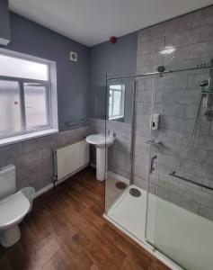 a bathroom with a shower and a toilet and a sink at Xtasia Adult Hotel - Adults Only in West Bromwich