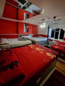 2 camas en una habitación con paredes rojas en Xtasia Adult Hotel - Adults Only, en West Bromwich