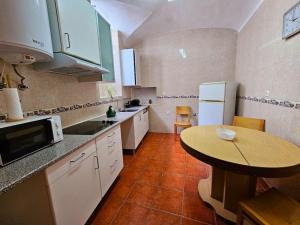 a kitchen with a table and a small table in it at Casa do Castelo III in Arraiolos