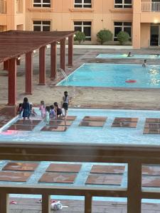 un grupo de niños jugando en una piscina en Tolip marina tower توليب ابراج المارينا غرفتين وصاله en King Abdullah Economic City