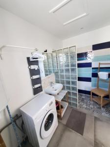 een badkamer met een wasmachine en een wastafel bij La casa Elisa Gîte T2 indépendant in Gréoux-les-Bains