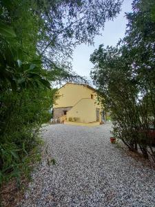a large yellow building on a gravel driveway at Seme di Luna in Canneto