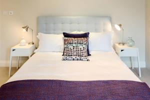 een slaapkamer met een groot wit bed en 2 nachtkastjes bij Madison Hill - White Hill House 5 - 3 bedroom flat in Londen