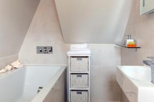 a white bathroom with a tub and a sink at Madison Hill - White Hill House 5 - 3 bedroom flat in London