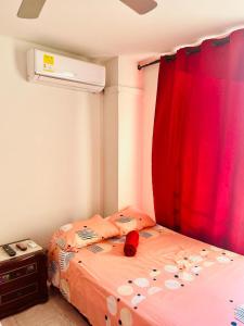 a bedroom with a bed with a red curtain at Santa Marta Apartamentos Salazar - Nuevo Rodadero in Santa Marta