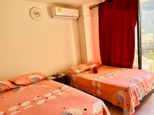 2 camas individuales en una habitación con ventana en Santa Marta Apartamentos Salazar - Nuevo Rodadero en Santa Marta