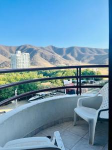 a balcony with two chairs and a view of the mountains at Santa Marta Apartamentos Salazar - Nuevo Rodadero in Santa Marta