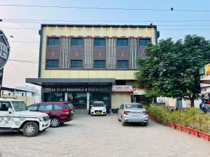 普杰Hotel Tulsi Residency的停车场里停着汽车的建筑物