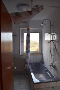 baño con bañera grande y ventana en Hunsrück en Schauren