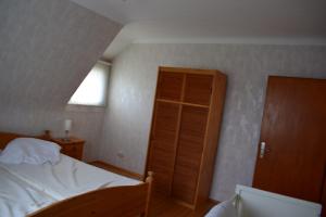 1 dormitorio con 1 cama y armario de madera en Hunsrück en Schauren