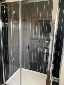 y baño con ducha y puerta de cristal. en Impeccable 3-Bed House in Birmingham en Birmingham