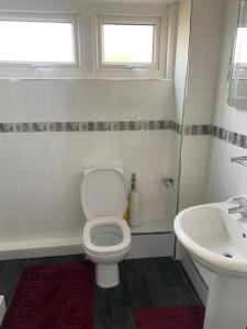 a bathroom with a toilet and a sink at Impeccable 3-Bed House in Birmingham in Birmingham