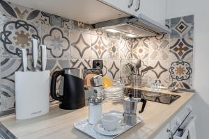 a kitchen counter with a coffee maker and cups on it at Nel cuore del rione del Drago in Pistoia