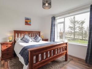 a bedroom with a bed and a large window at Taigh Neilag in Elgol