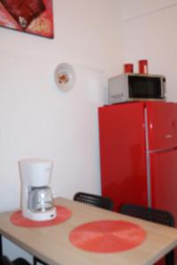Mona Hause في أثينا: مطبخ مع طاولة مع خلاط وثلاجة حمراء
