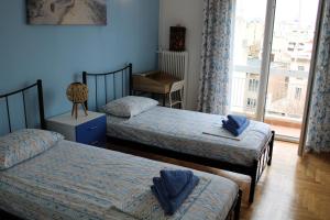een slaapkamer met 2 bedden en een raam bij Mona Hause in Athene