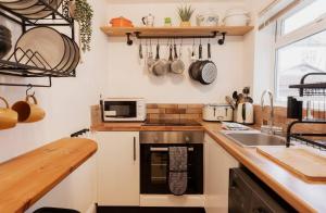 a small kitchen with a sink and a microwave at Well located Cosy 2 bedroom home near Chester centre in Chester