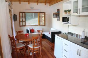 a kitchen and dining room with a table and a couch at La Linda Cabañas in Dos de Mayo