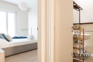 ein Schlafzimmer mit einem Bett und ein Badezimmer mit einem Waschbecken in der Unterkunft Viareggio - Via Pisano 61 Valente Italian Properties in Viareggio