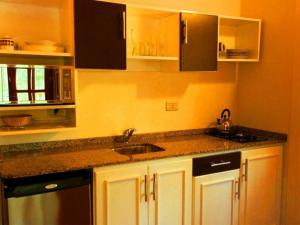 a kitchen with white cabinets and a sink at La Linda Cabañas in Dos de Mayo