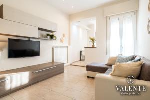ein Wohnzimmer mit einem TV und einem Sofa in der Unterkunft Viareggio - Via Pisano 61 Valente Italian Properties in Viareggio