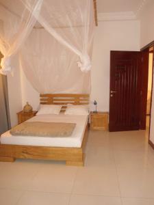 a bedroom with a bed with a mosquito net at Daaru Jamm in Dakar