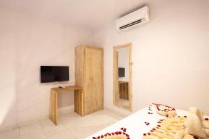 a bedroom with a bed and a tv and a mirror at Maisaba Seminyak Loft & Villas in Seminyak