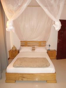una camera con letto a baldacchino di Daaru Jamm a Dakar