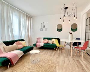 a living room with a green couch and a table at Apartamentos 2K - Apartamento de diseño en centro de Castro Urdiales in Castro-Urdiales