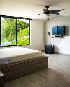 a bedroom with a large bed and a flat screen tv at Zoi Eco Hotel in Manizales