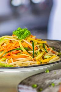 a plate of noodles and vegetables on a table at Zoi Eco Hotel in Manizales