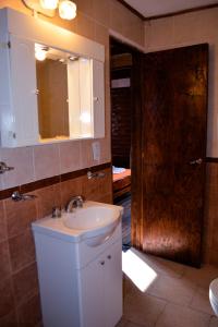 a bathroom with a sink and a mirror and a door at Patagonia Cabañas in Las Gaviotas