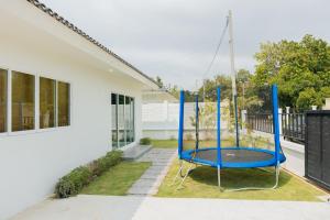 a blue swing in the yard of a house at Private 3BR Pool House Near Pattaya Beach in Ban Huai Yai