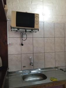 a microwave on a wall next to a sink at CG ALQUILERES in Tacuarembó