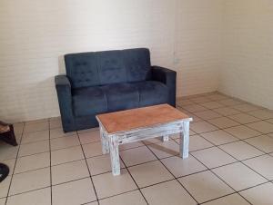 CG ALQUILERES في تاكوارمبو: أريكة زرقاء وطاولة قهوة في الغرفة