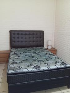 a bed in a room with a black head board at CG ALQUILERES in Tacuarembó