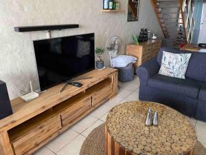 a living room with a large flat screen tv at Modern and Stylish beach pad with Stunning Ocean View in Ballito
