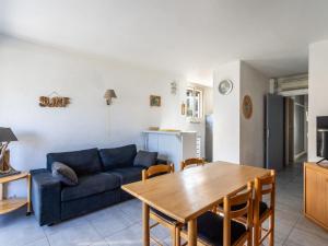 uma sala de estar com um sofá azul e uma mesa em Apartment L'Estelan-1 by Interhome em Le Lavandou