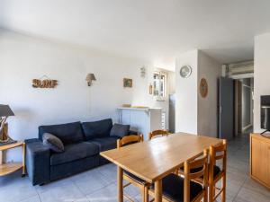 a living room with a blue couch and a table at Apartment L'Estelan-1 by Interhome in Le Lavandou